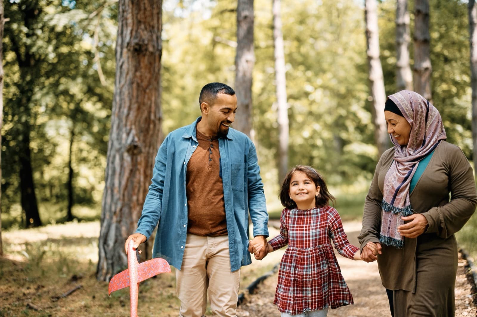 A man, a woman and a girl walking in woodland