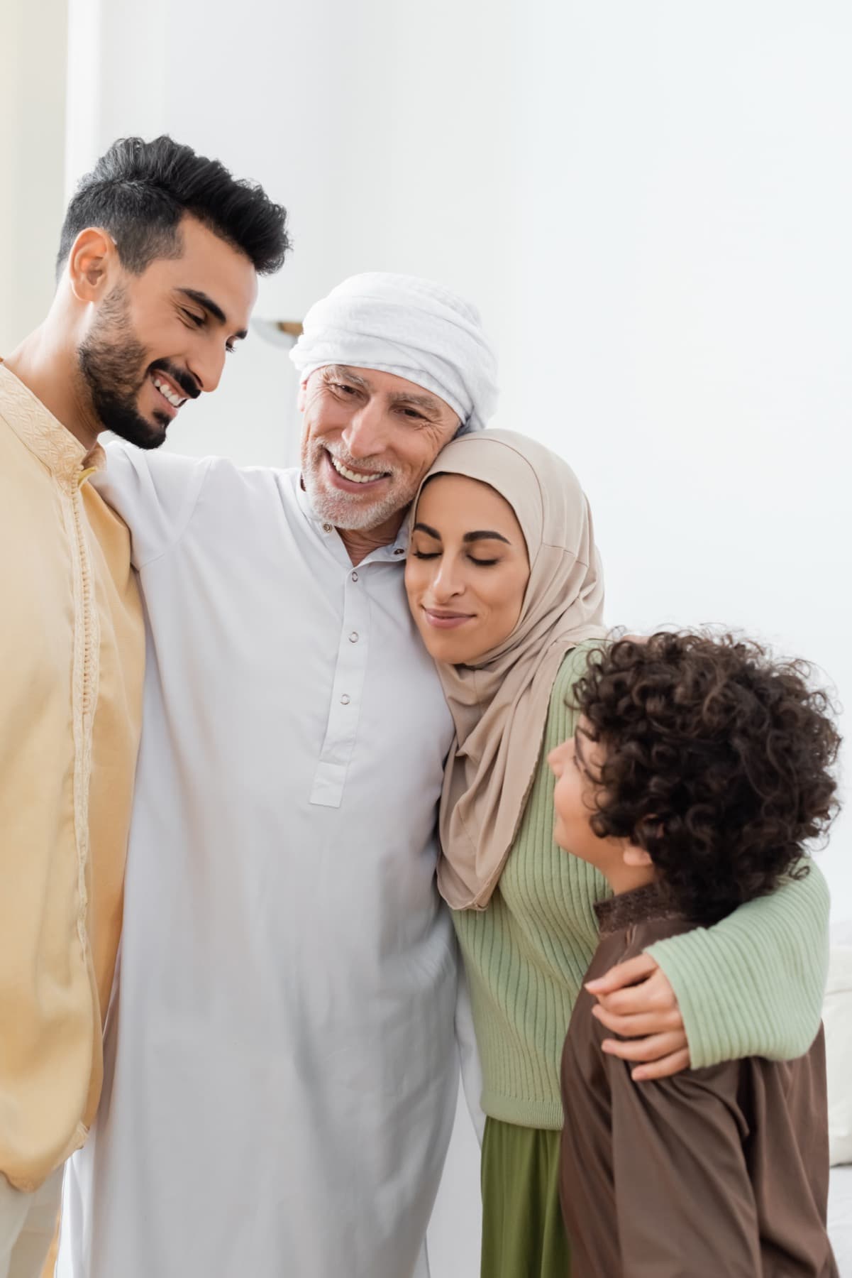 Four people smiling and embracing