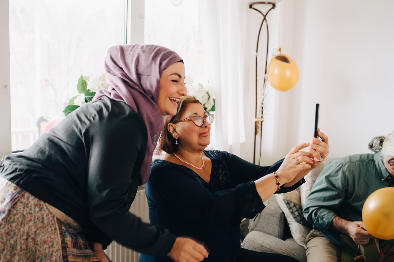 Two women smiling at a phone