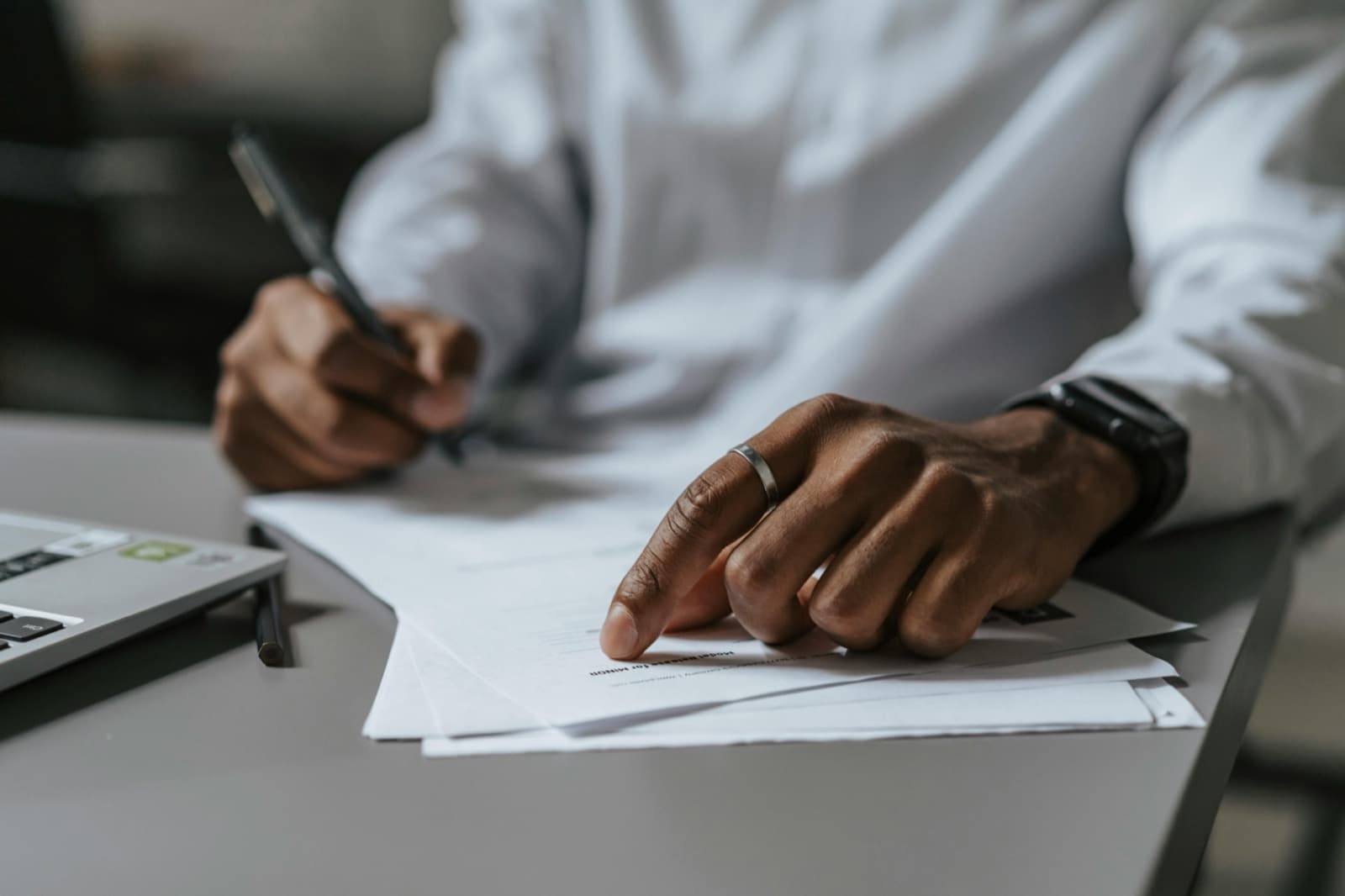 A person signing papers at a desk